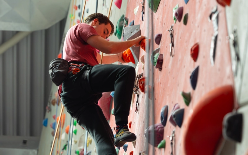 Climber concentrating on a route on an indoor wall